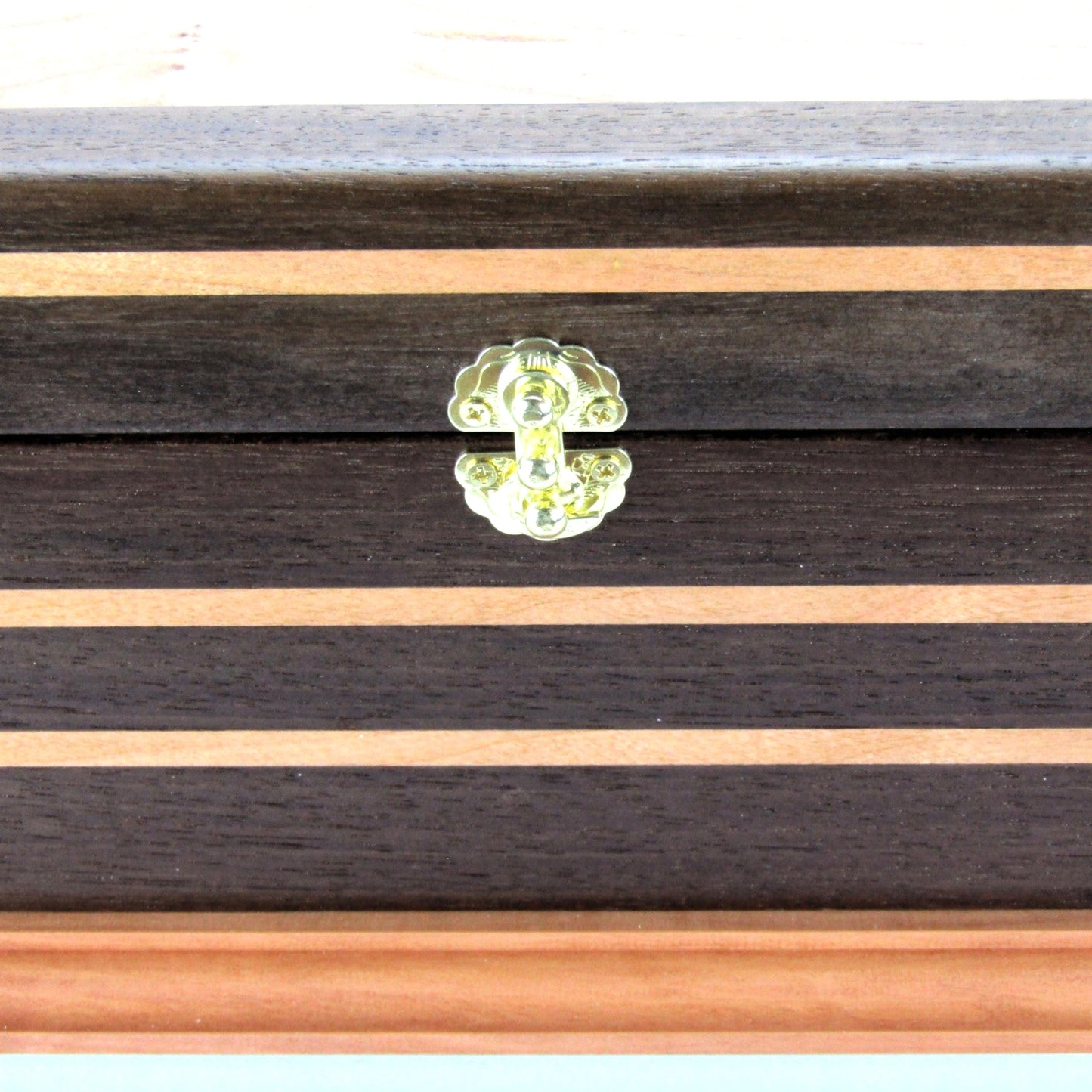 Inlays on handmade keepsake box crafted from Peruvian walnut, cherry, cherry veneer, and a pear base by A Finer Cut Woodworking.