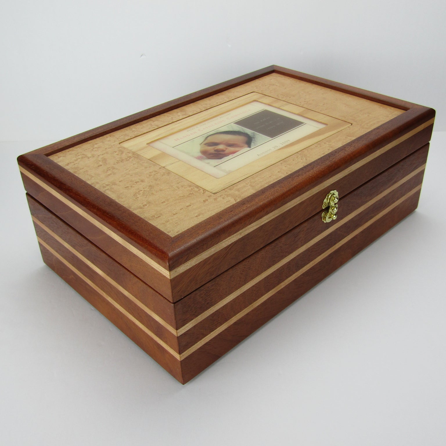 Front corner view of children's memory box with photo lid handmade from mahogany, cherry, and maple burl veneer by A Finer Cut Woodworking. 