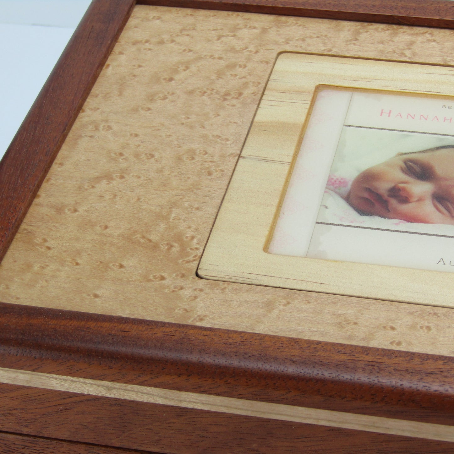 Lid details on children's memory box with photo lid handmade from mahogany, cherry, and maple burl veneer by A Finer Cut Woodworking. 