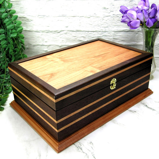 Thumbnail of handmade keepsake box crafted from Peruvian walnut, cherry, cherry veneer, and a pear base by A Finer Cut Woodworking.