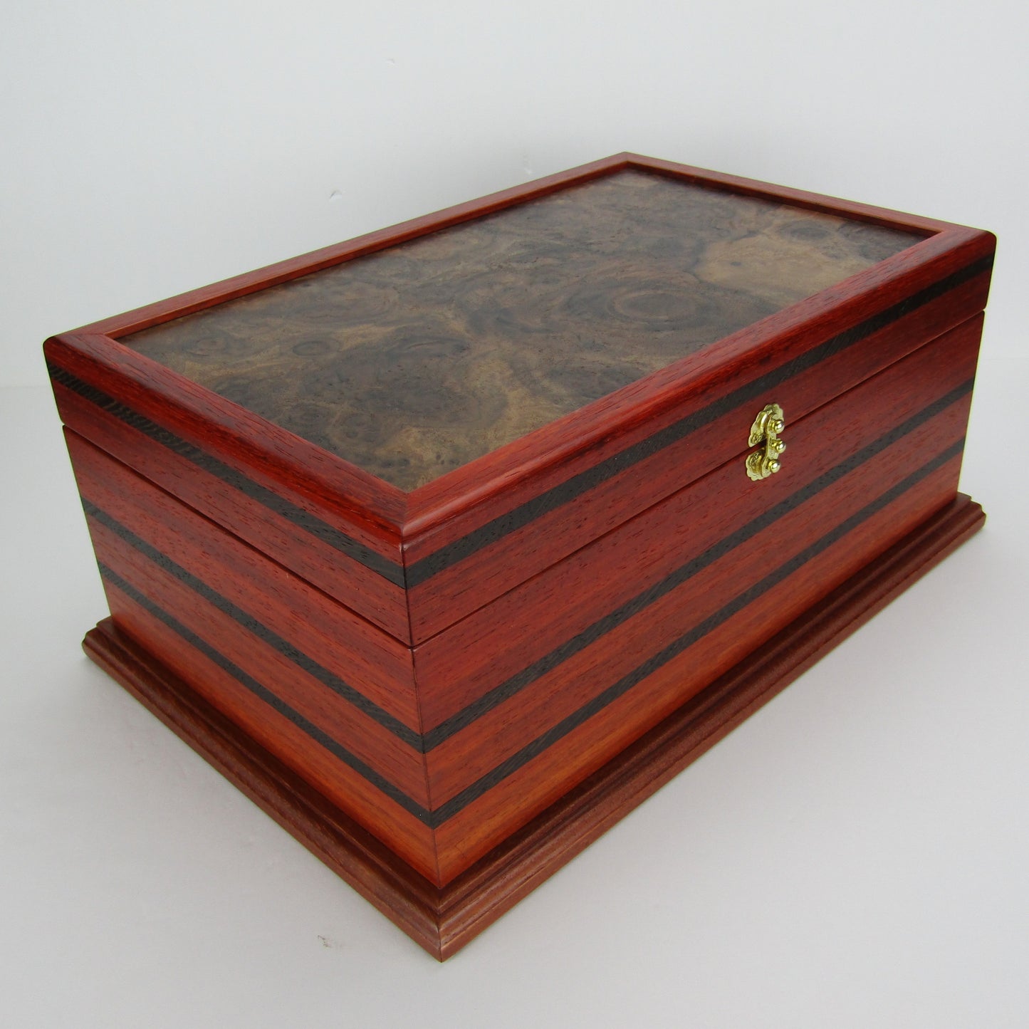 Front corner view of handmade wooden box crafted from padauk, wenge, Brazilian cherry, and walnut burl veneer by A Finer Cut Woodworking.