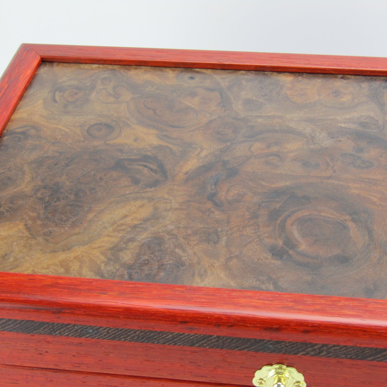Lid details on handmade wooden box crafted from padauk, wenge, Brazilian cherry, and walnut burl veneer by A Finer Cut Woodworking.