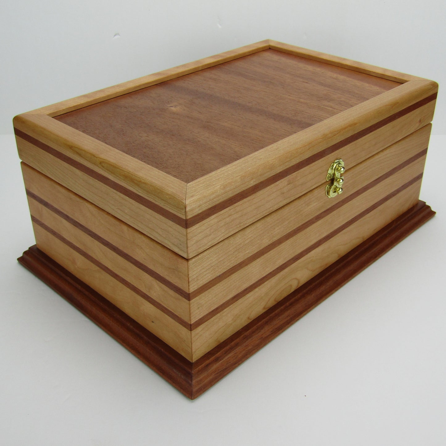 Front corner view of handmade wood jewelry box crafted from cherry, mahogany, and mahogany veneer by A Finer Cut Woodworking.