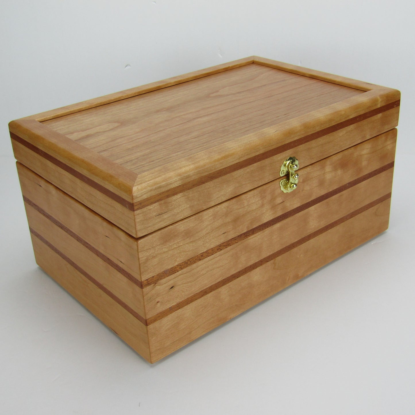 Front corner view of large keepsake box handmade from cherry, mahogany, and cherry veneer by A Finer Cut Woodworking.