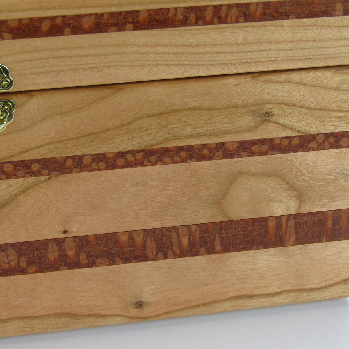 Inlays on large keepsake box handmade from quilted cherry, leopardwood, and cherry veneer by A Finer Cut Woodworking.
