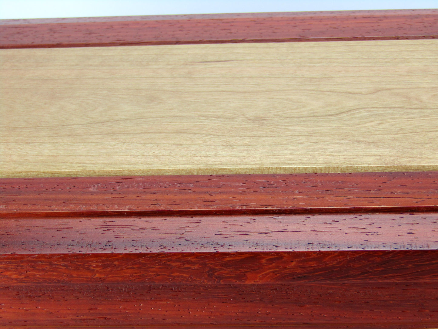 Lid details on large keepsake box with raised panels handcrafted from padauk and cherry wood by A Finer Cut.