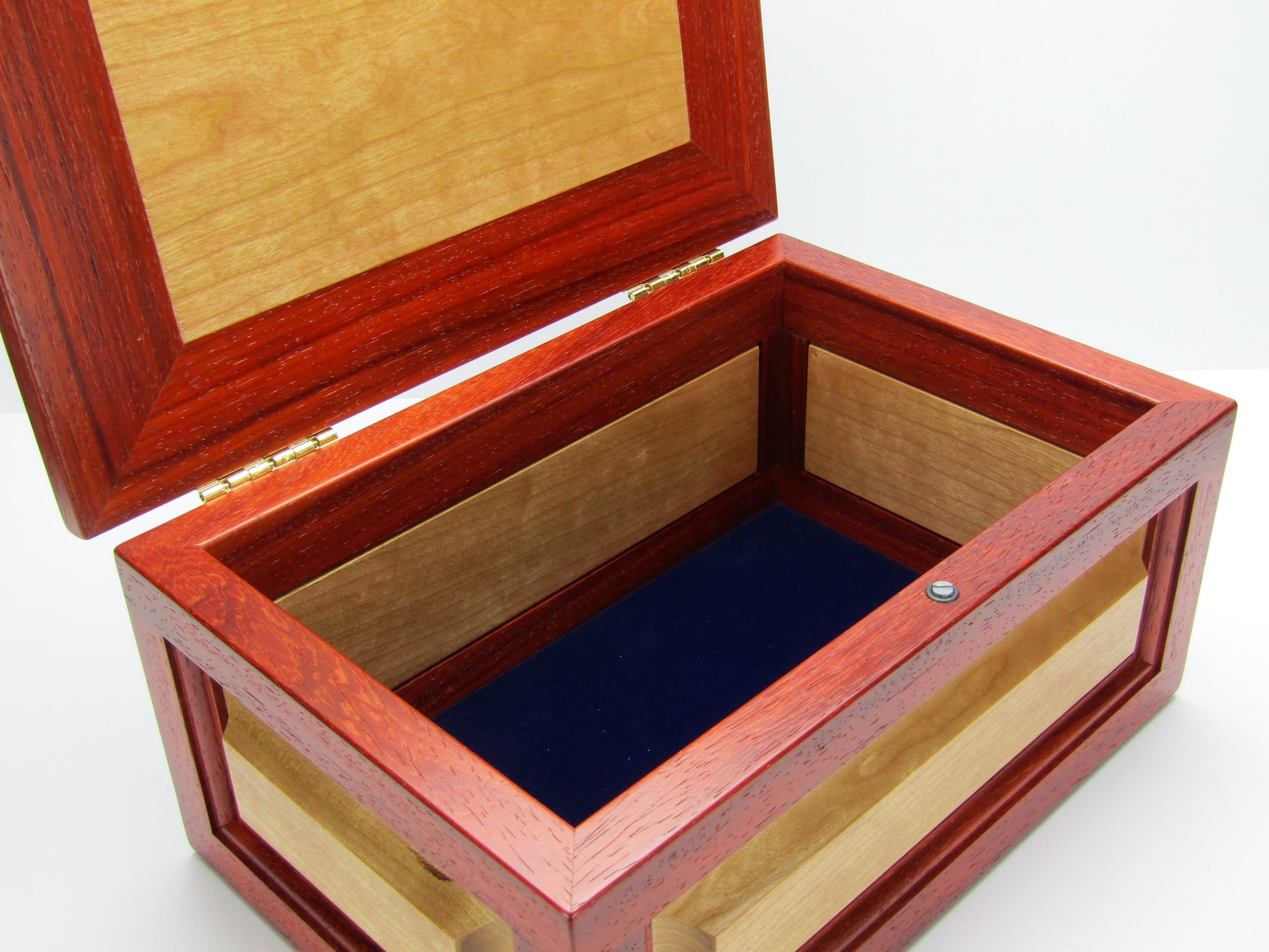 Interior view of large keepsake box with raised panels handcrafted from padauk and cherry wood by A Finer Cut.