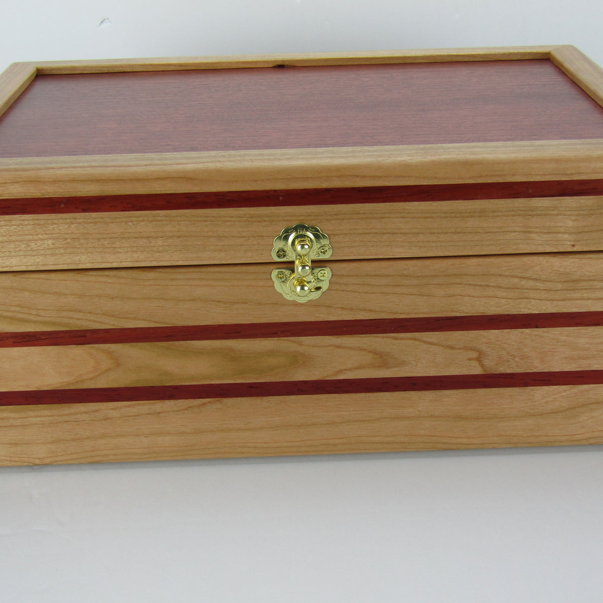 Front view of unique memorial box handcrafted from domestic cherry, padauk, and dark finished cherry veneer by A Finer Cut Woodworking. 
