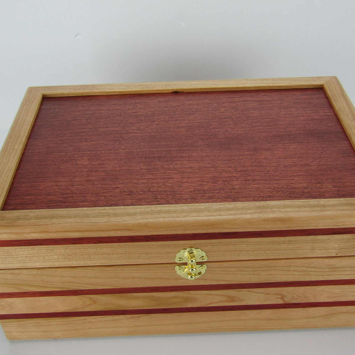 Top view of unique memorial box handcrafted from domestic cherry, padauk, and dark finished cherry veneer by A Finer Cut Woodworking. 