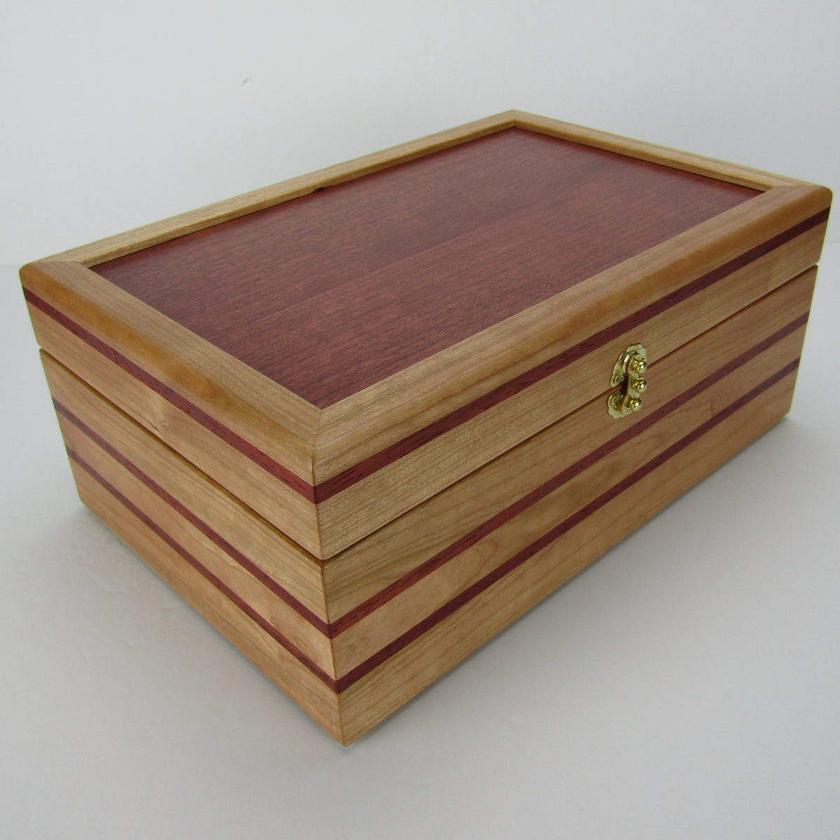 Front corner view of unique memorial box handcrafted from domestic cherry, padauk, and dark finished cherry veneer by A Finer Cut Woodworking. 