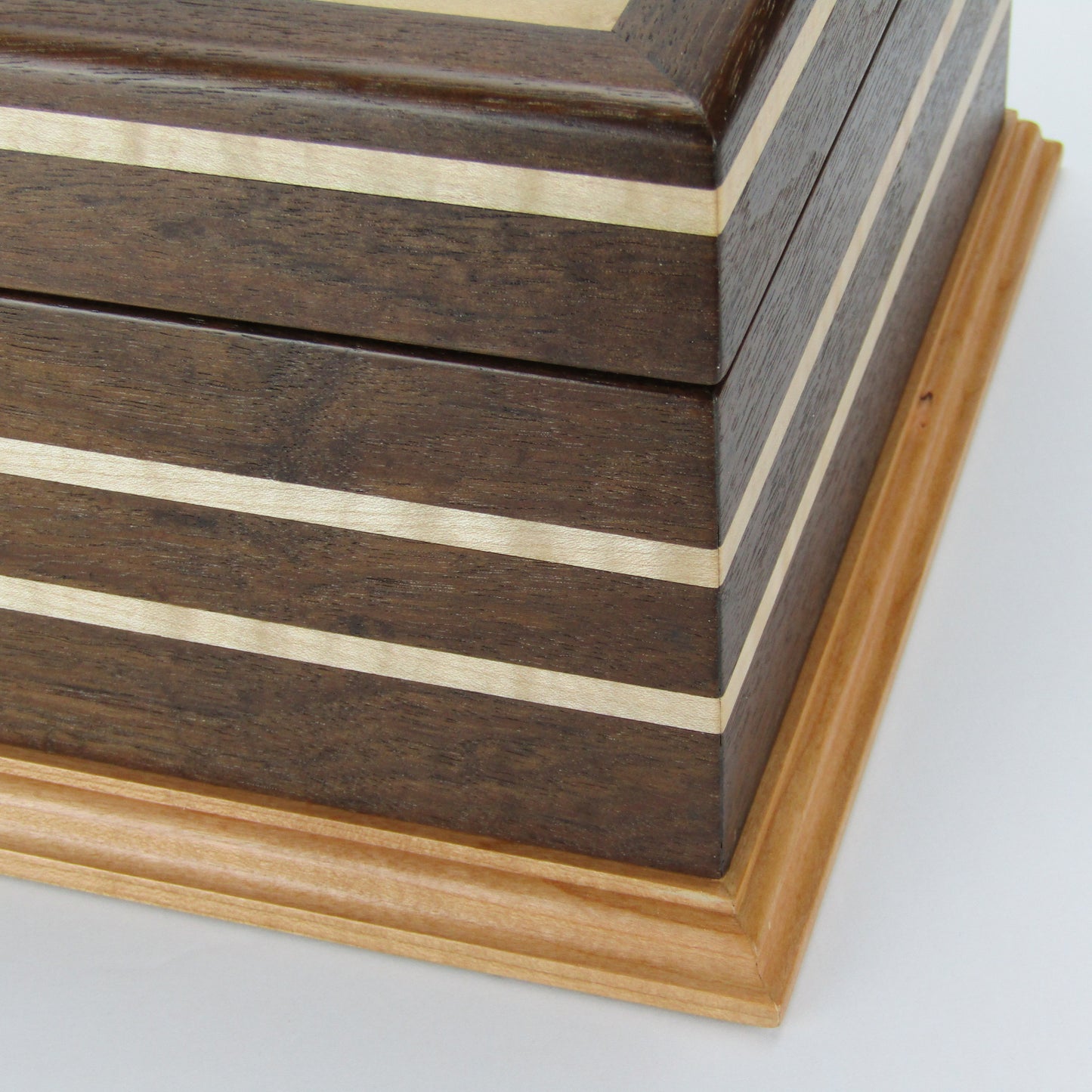 Front view of unique memorial keepsake box handmade from Peruvian walnut, curly maple, cherry, and bird's eye maple veneer  by A Finer Cut Woodworking.