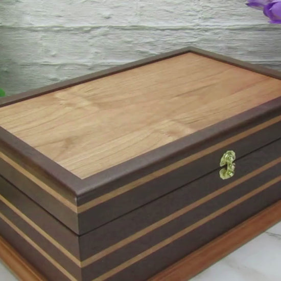 Video showing details of handmade keepsake box crafted from Peruvian walnut, cherry, cherry veneer, and a pear base by A Finer Cut Woodworking.