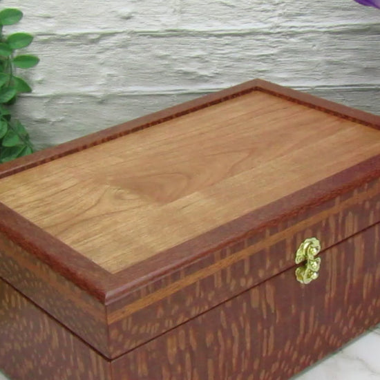 Video showing details of valet box for men handcrafted from leopardwood with mahogany inlay by A Finer Cut Woodworking.