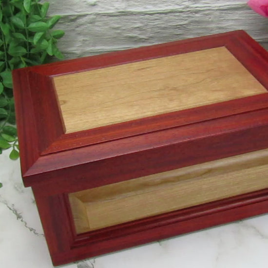 Video showing details of large keepsake box with raised panels handcrafted from padauk and cherry wood by A Finer Cut.