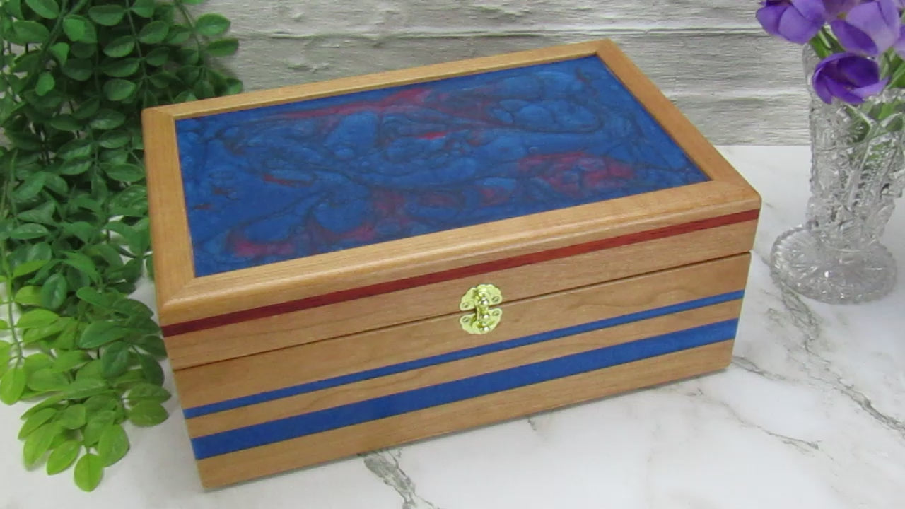 Video showing details of keepsake memory box handmade from cherry wood with padauk and epoxy inlays by A Finer Cut Woodwork.