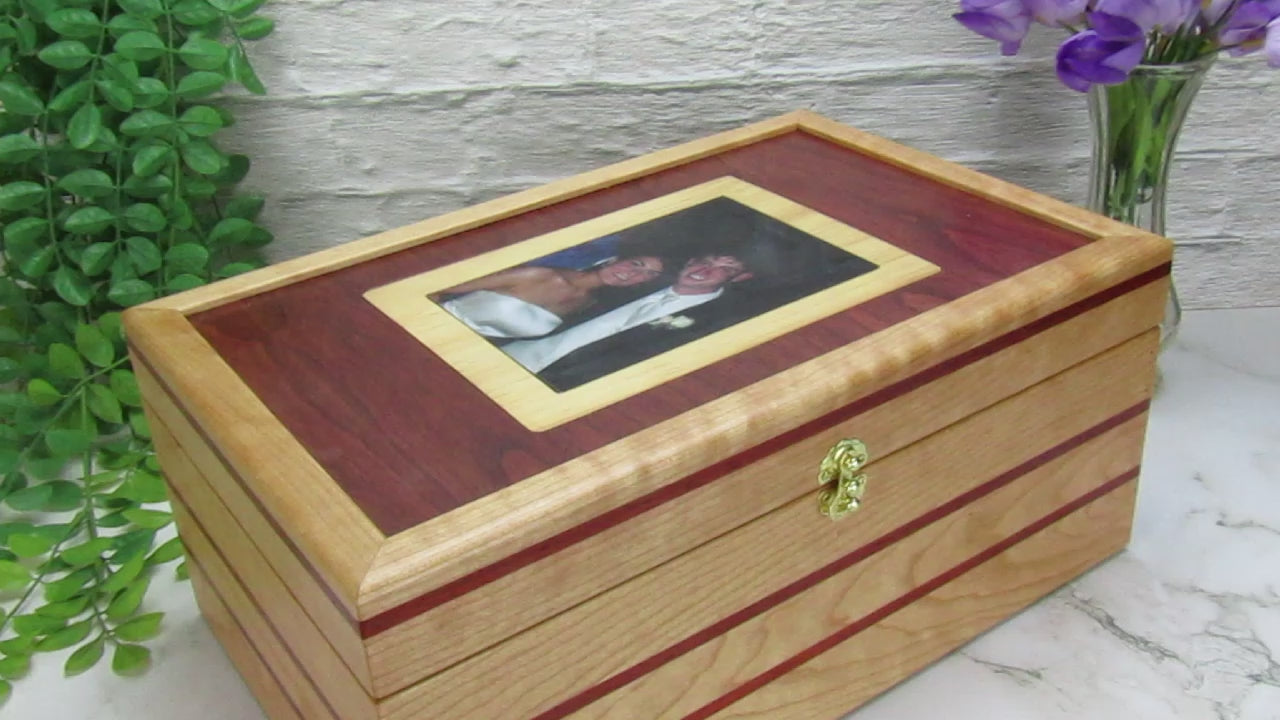 Video showing details of memory box with photo lid handcrafted from cherry, padauk, and dark finished cherry veneer by A Finer Cut Woodworking. 