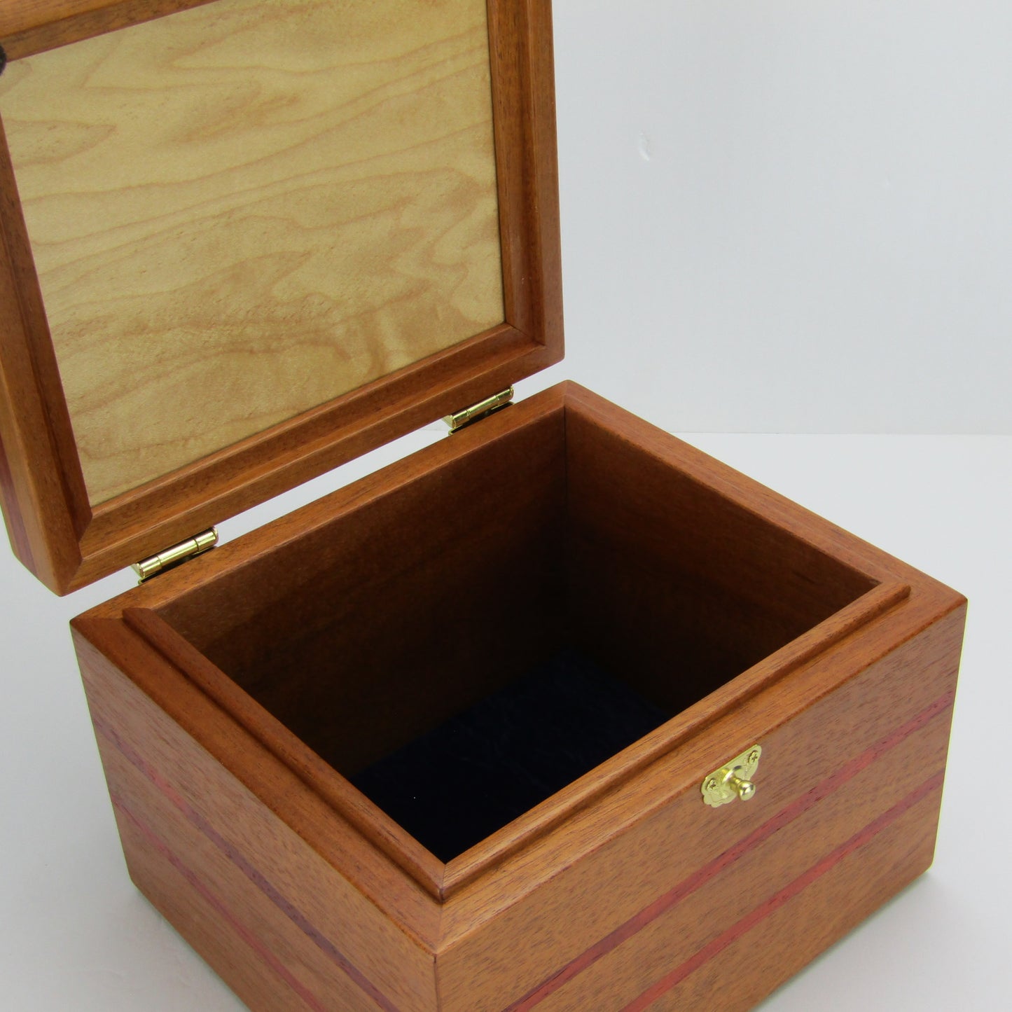 Interior view of unique small keepsake box handmade from mahogany, padauk, and red finished cherry veneer by A Finer Cut Woodworking.