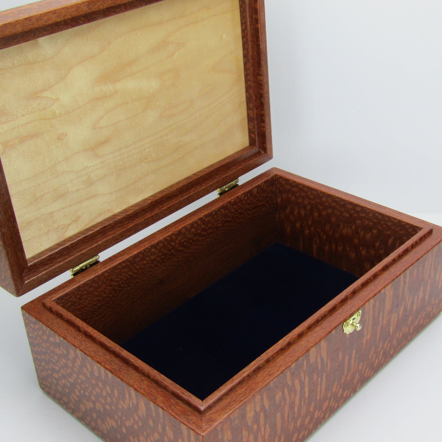 Interior view of valet box for men handcrafted from leopardwood with mahogany inlay by A Finer Cut Woodworking.