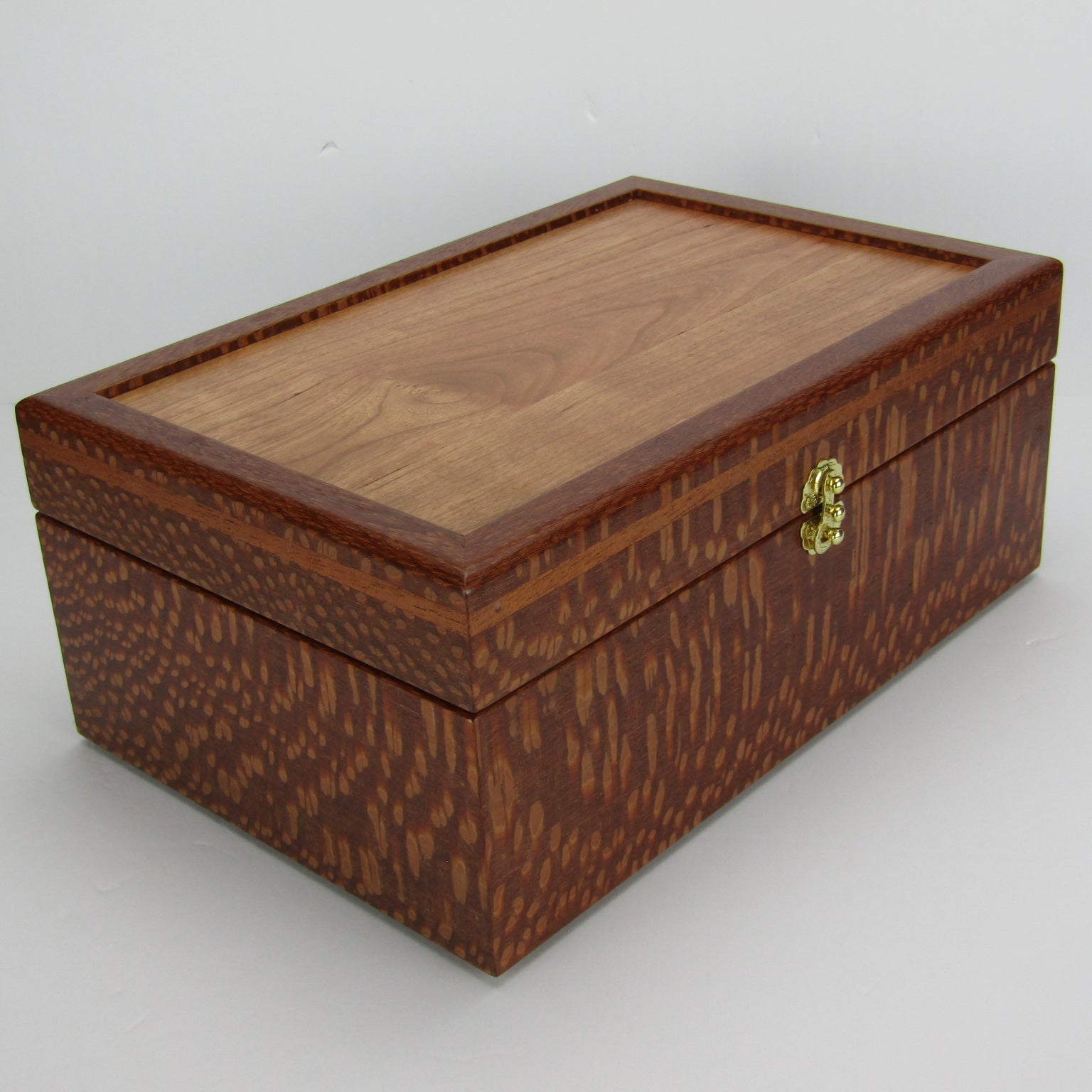 Front corner view of valet box for men handcrafted from leopardwood with mahogany inlay by A Finer Cut Woodworking.