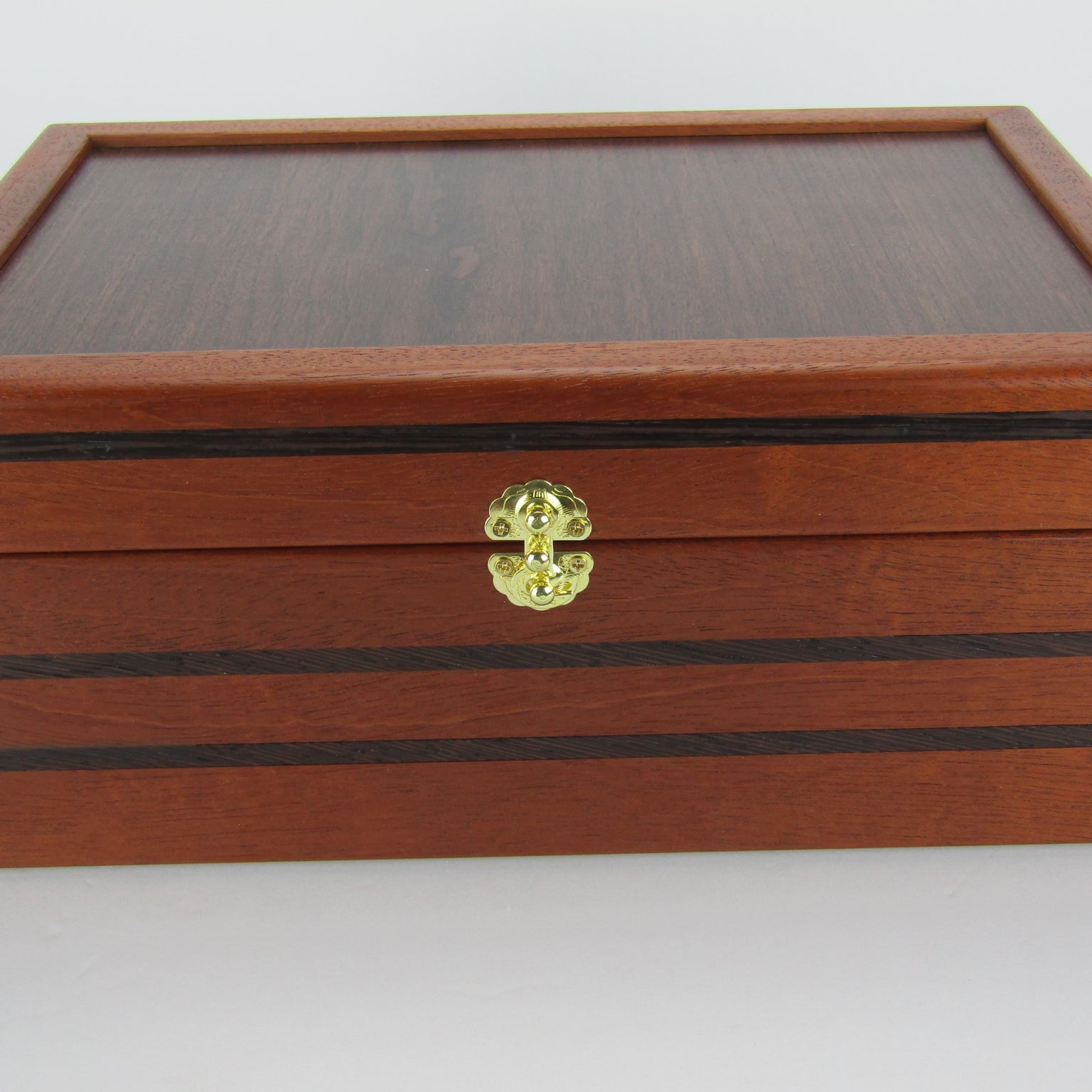 Front view of valet box for men handcrafted from mahogany, with wenge inlay and a dark finished cherry veneer lid  by A Finer Cut Woodworking.