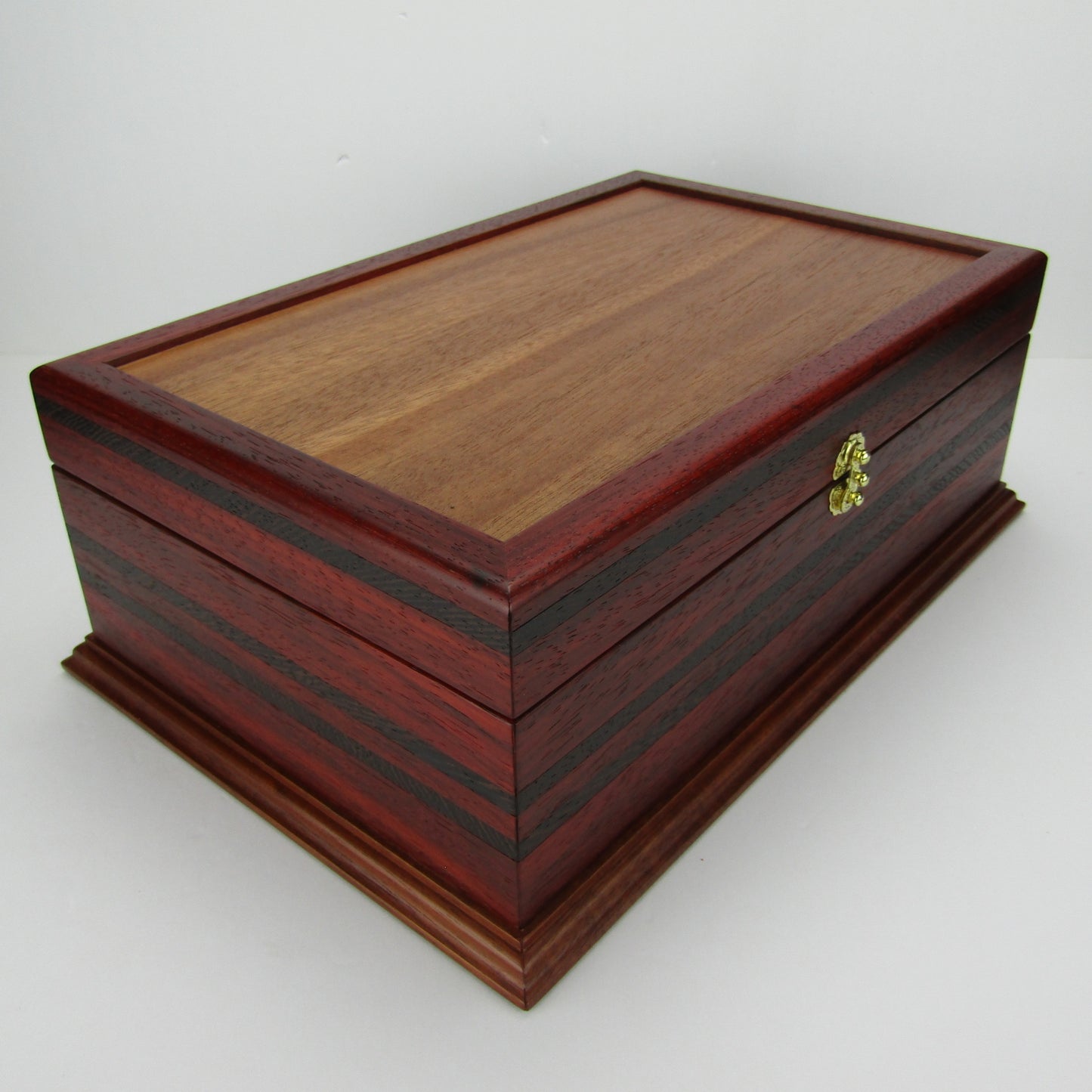 Front corner view of wooden keepsake box handmade from padauk, wenge, and cherry veneer by A Finer Cut Woodworking.