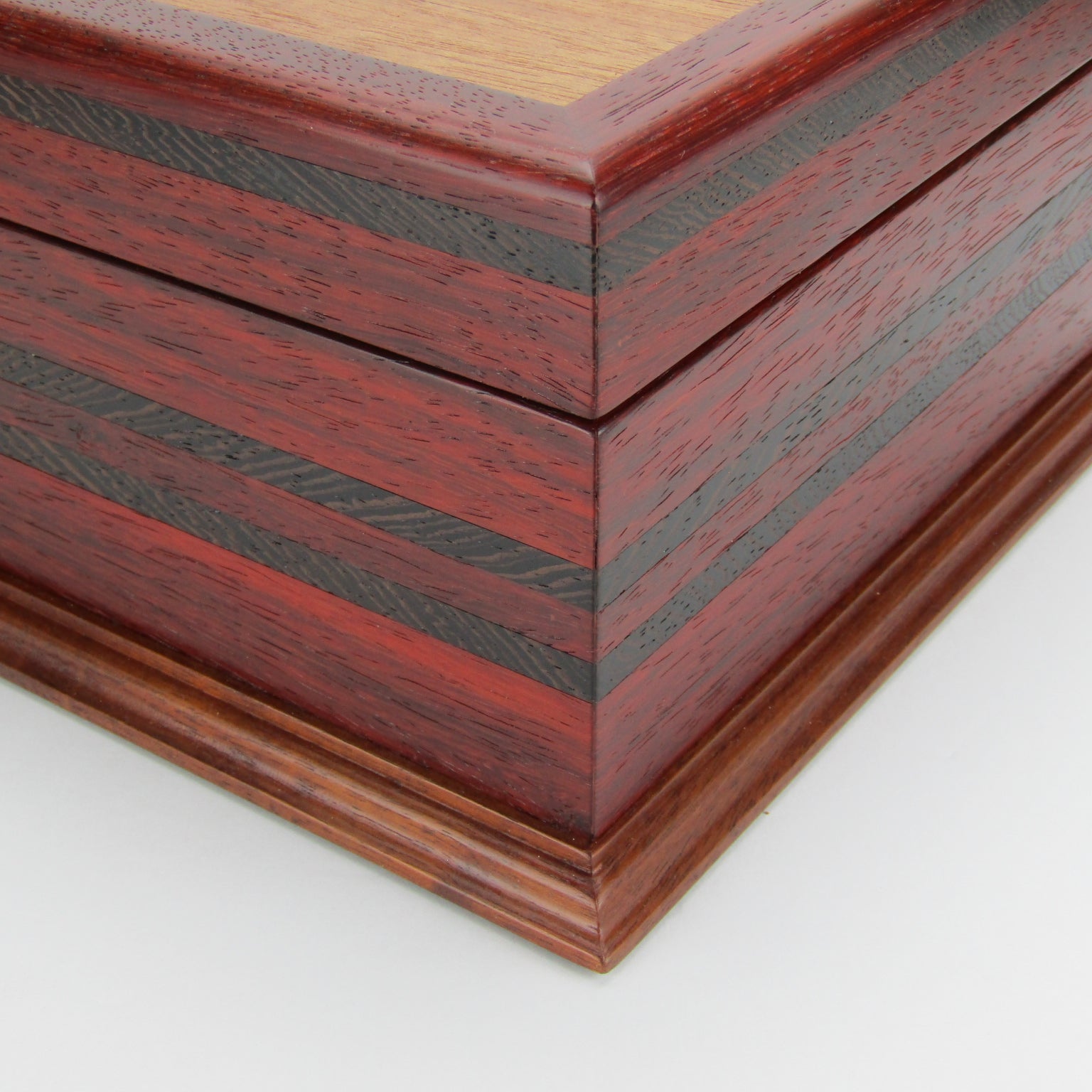 Inlays on wooden keepsake box handmade from padauk, wenge, and cherry veneer by A Finer Cut Woodworking.